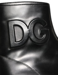Dolce & Gabbana men's black leather ankle boots with embossed logo and side zipper, front three-quarter view.