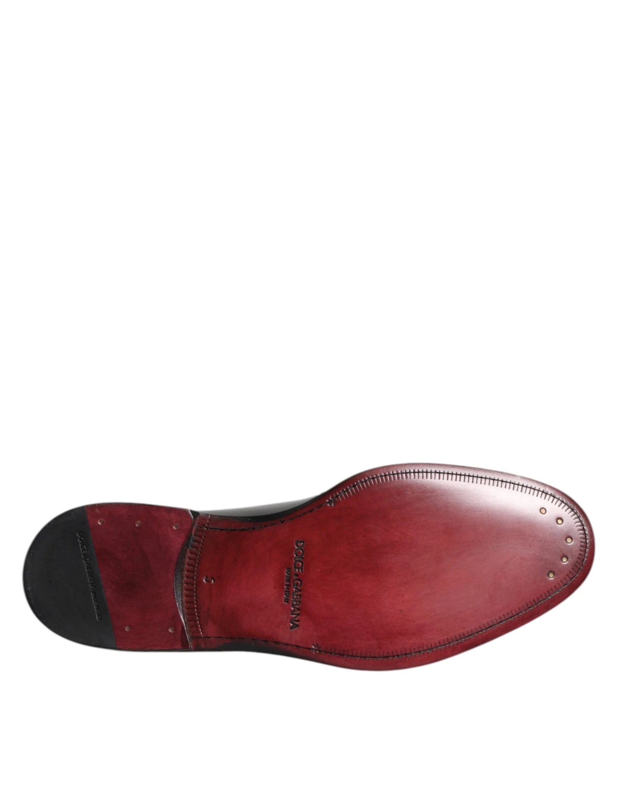 Imagine macro a cusăturilor fine și a suprafeței lustruite din piele a pantofilor Derby negri Dolce & Gabbana.