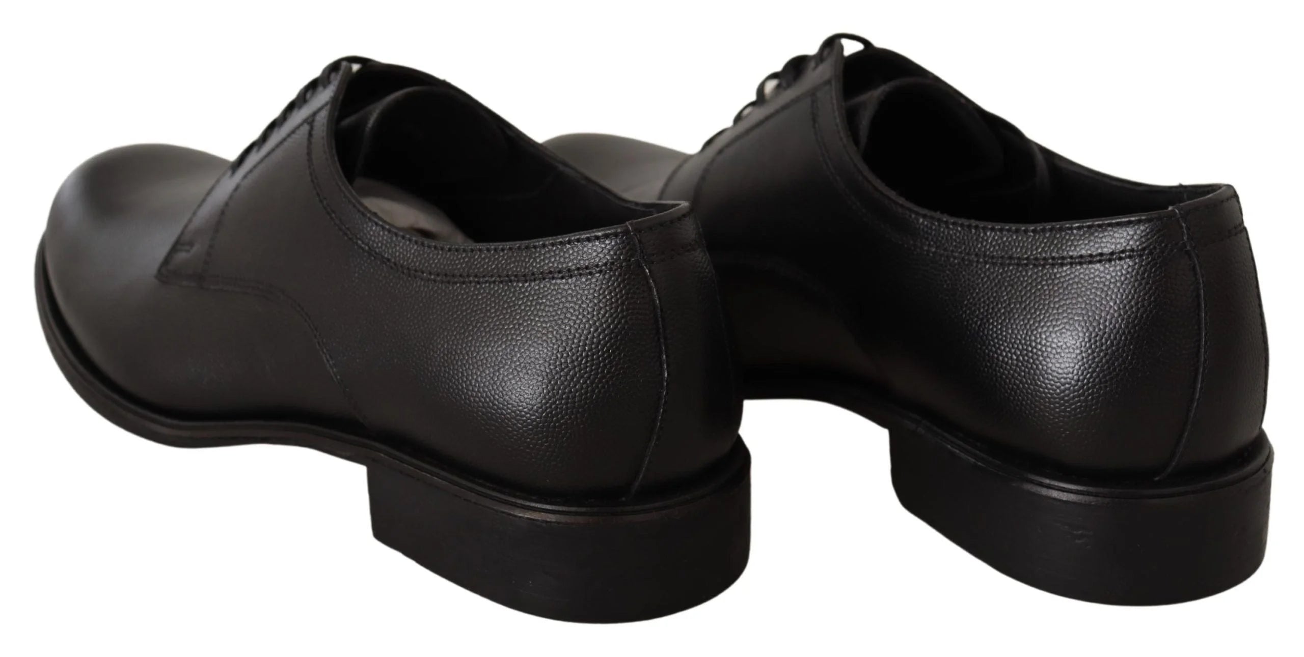 Perfil lateral dos sapatos formais pretos Dolce & Gabbana em couro, destacando a silhueta elegante e o salto empilhado.
