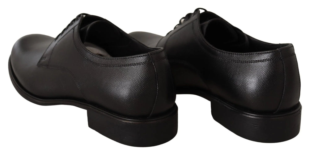 Perfil lateral dos sapatos formais pretos Dolce & Gabbana em couro, destacando a silhueta elegante e o salto empilhado.