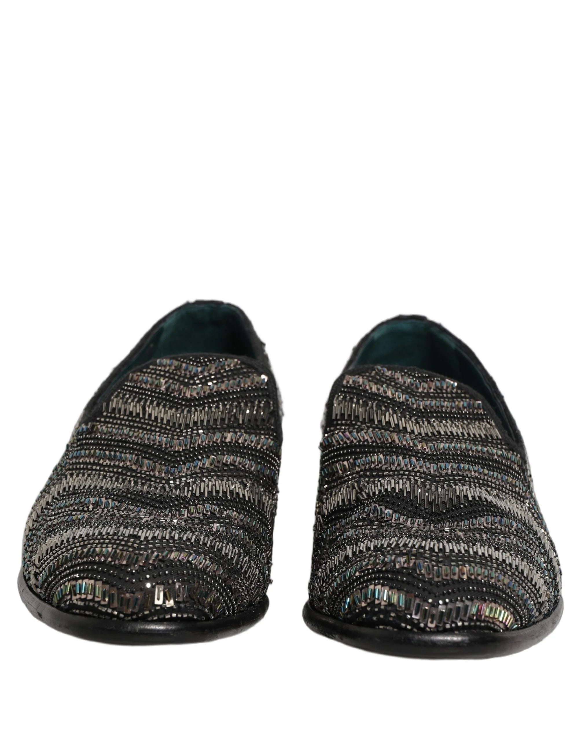 Vista lateral de los mocasines de cuero negro de Dolce & Gabbana que muestran la silueta elegante y la ornamentación de cuentas plateadas.