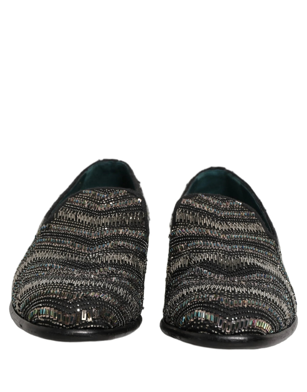 Vista lateral de los mocasines de cuero negro de Dolce & Gabbana que muestran la silueta elegante y la ornamentación de cuentas plateadas.