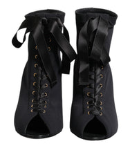 Dolce & Gabbana black leather ankle boots featuring a pointed toe, lace-up front, and elegant stiletto heel.