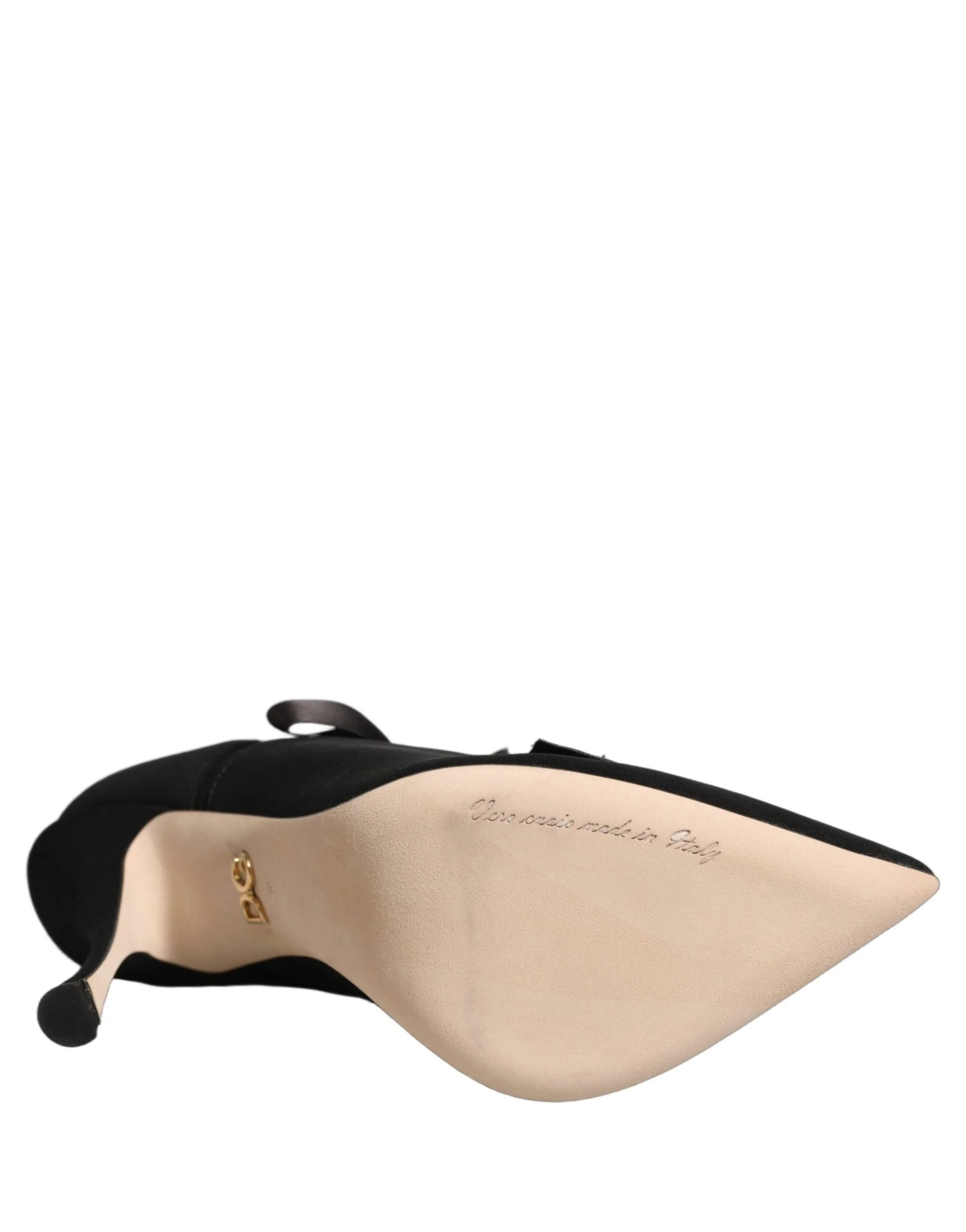 Schräger Blick auf luxuriöse Dolce & Gabbana schwarze Stiefel, die die raffinierte spitz zulaufende Zehenpartie und die hochwertige Stoffveredelung betonen.