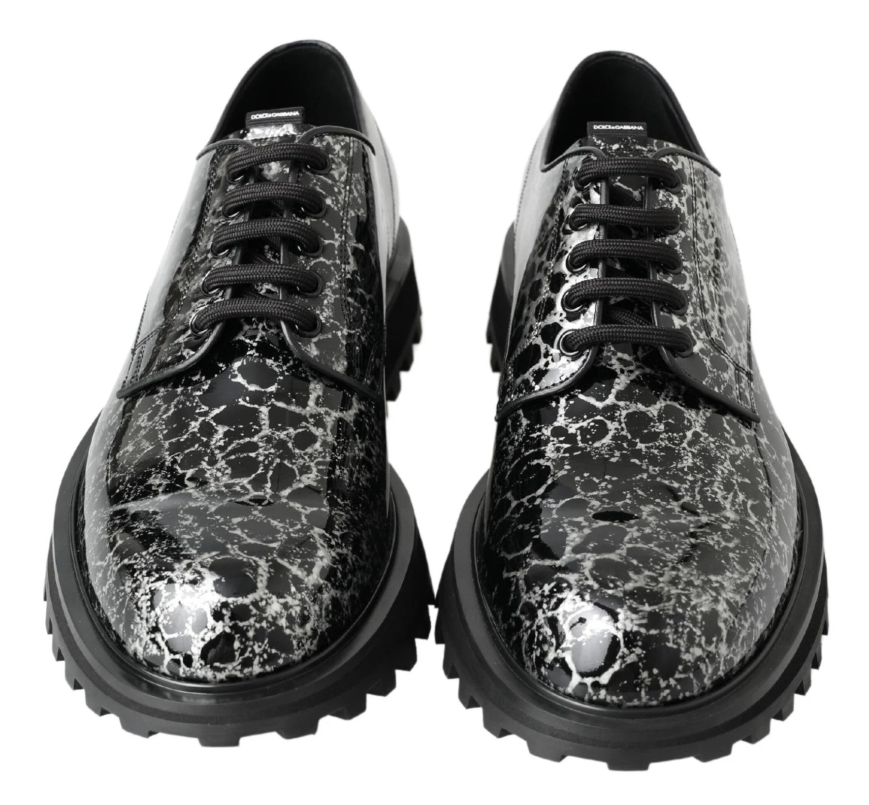Pormenor da textura de couro patente de alto brilho e dos atacadores encerados destes sapatos masculinos de luxo Dolce & Gabbana.