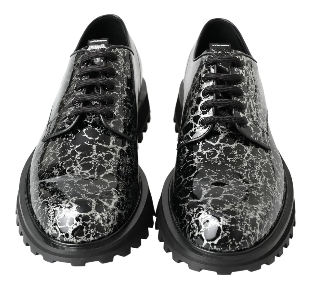 Pormenor da textura de couro patente de alto brilho e dos atacadores encerados destes sapatos masculinos de luxo Dolce & Gabbana.