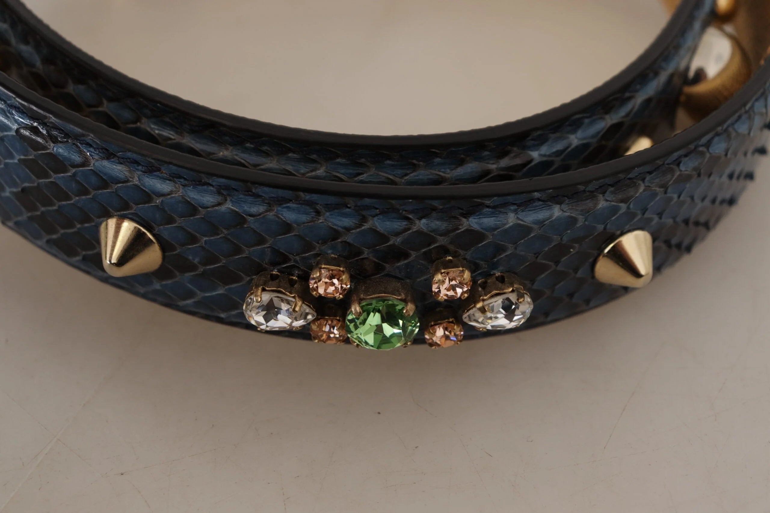 Detailní záběr luxusního popruhu kabelky Dolce & Gabbana zdůrazňující řemeslné zpracování 100% hadí kůže a třpytivé křišťálové detaily.