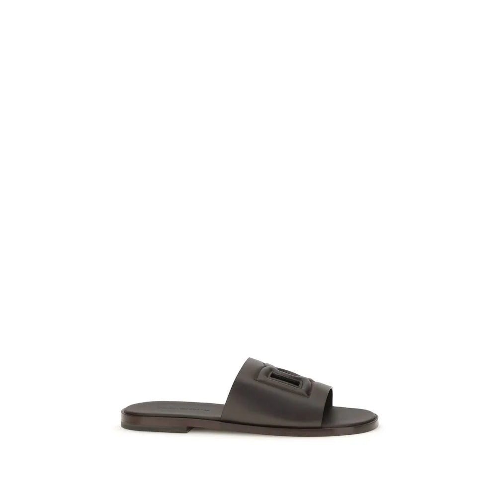 Dolce & Gabbana pruunast veise nahast Bos Taurus lamedad sandaalid, mis on minimalistliku T-rihmaga kujundusega ja kuldse tooniga detailidega.