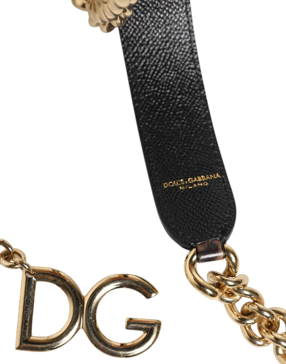 Close-up da textura em pele de bezerro com estampado de leopardo e da corrente em latão dourado numa correia de mala de luxo.