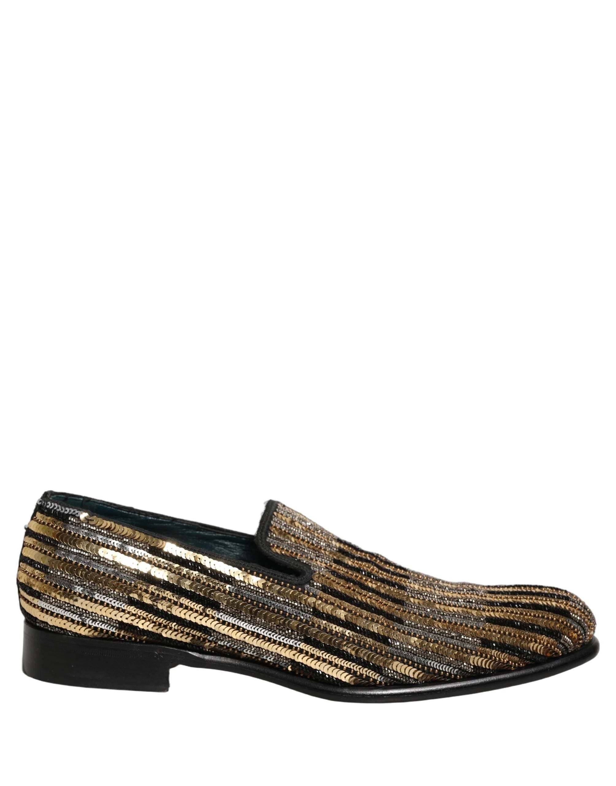 Mocassins Dolce & Gabbana à rayures dorées en sequins présentés dans un décor de studio, soulignant leur esthétique de soirée opulente.