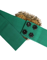 Close-up of the ornate gold-tone heart buckle on a Dolce & Gabbana green wide belt, showcasing intricate metalwork.