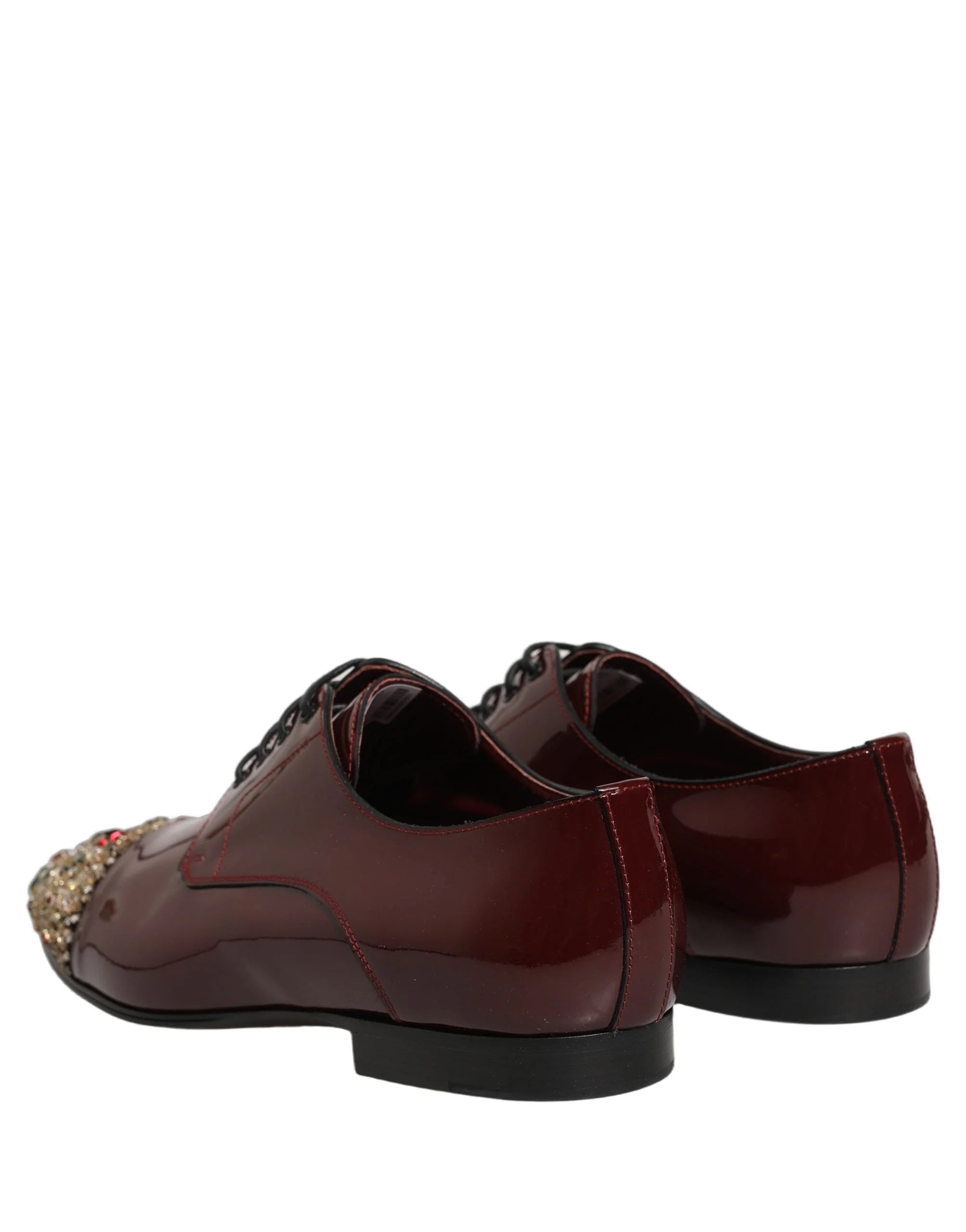 Ülaltvaade Dolce & Gabbana marooni kingadele, millel on keerukad kristallid toe ja paelte kohal.