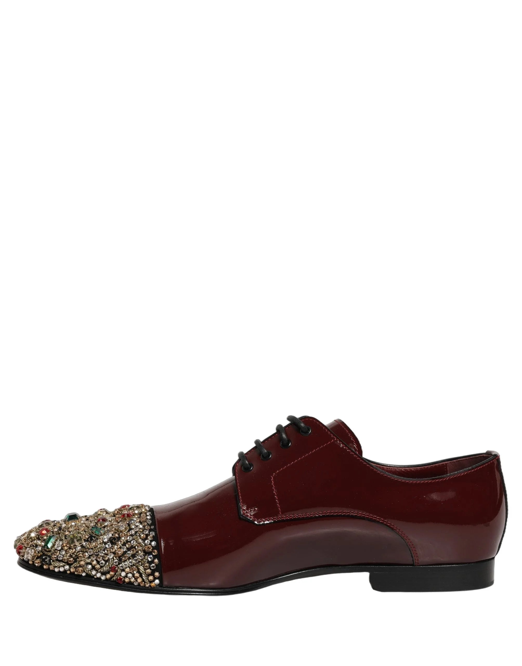 Suur vaade marooni nahatekstuurile ja sädelevatele kristallidele nende luksuslike Dolce & Gabbana kingade peal.
