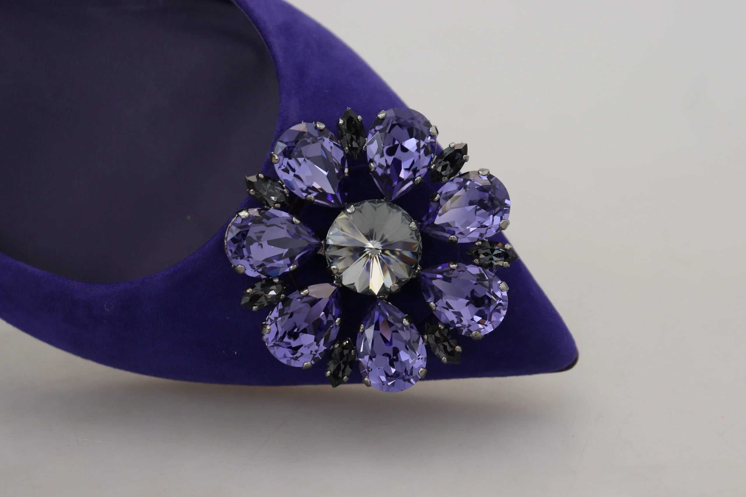 Schräger Blick auf die Dolce & Gabbana Ballerinas mit Kristallverzierungen aus violettem Suede, die die satte Farbe und das weiche Material betonen.