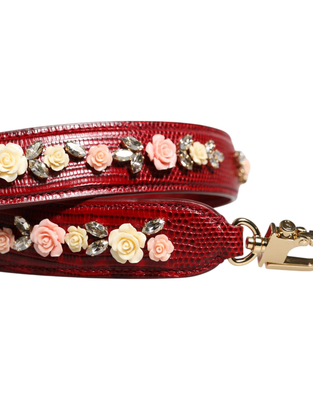 Közelkép az arany színű garnélarák csat és a domborított Dolce & Gabbana logó a piros bőr kiegészítőn.