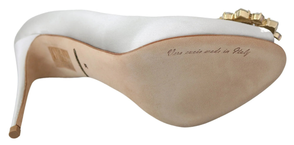 Dolce & Gabbanas hvide silk satin pumps med åben tå med intrikate krystaludsmykninger på en høj stilet hæl.