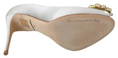 Dolce & Gabbanas hvide silk satin pumps med åben tå med intrikate krystaludsmykninger på en høj stilet hæl.