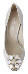 Sideprofil af Ameoros Dolce & Gabbana hvide satin hæle med funklende krystal accenter og elegant åben tå design.