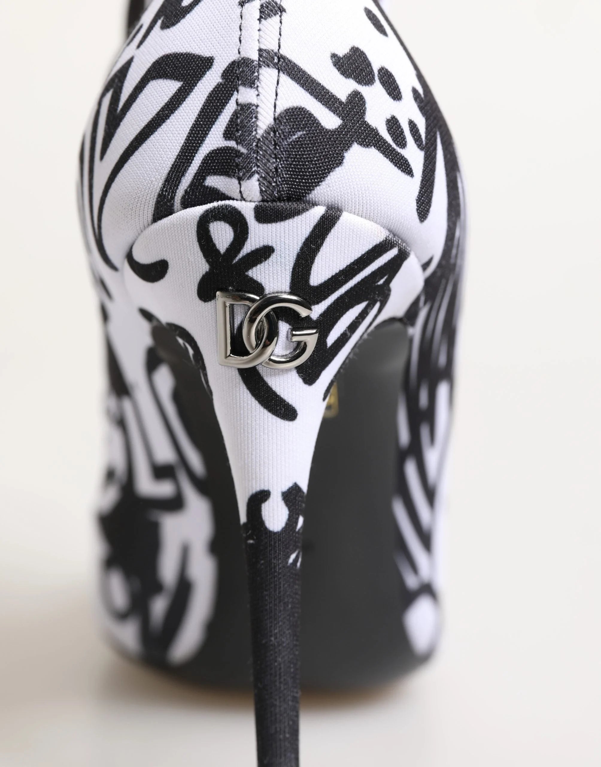 Makrovisning av stretch-tekstilmaterialet og kunstneriske graffiti-mønstre på disse Dolce & Gabbana luksus ankelstøvlene.