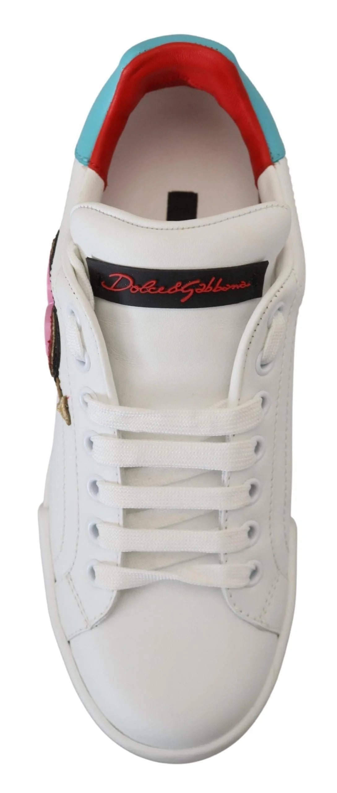 Imagen detallada de la placa del logotipo en tono dorado y la costura precisa en el sneaker Portofino de Dolce & Gabbana.