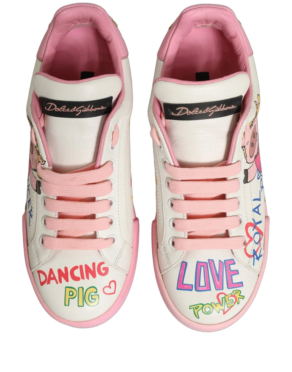 Side profile of Dolce & Gabbana white leather sneakers with whimsical pink pig illustrations and black logo lettering.