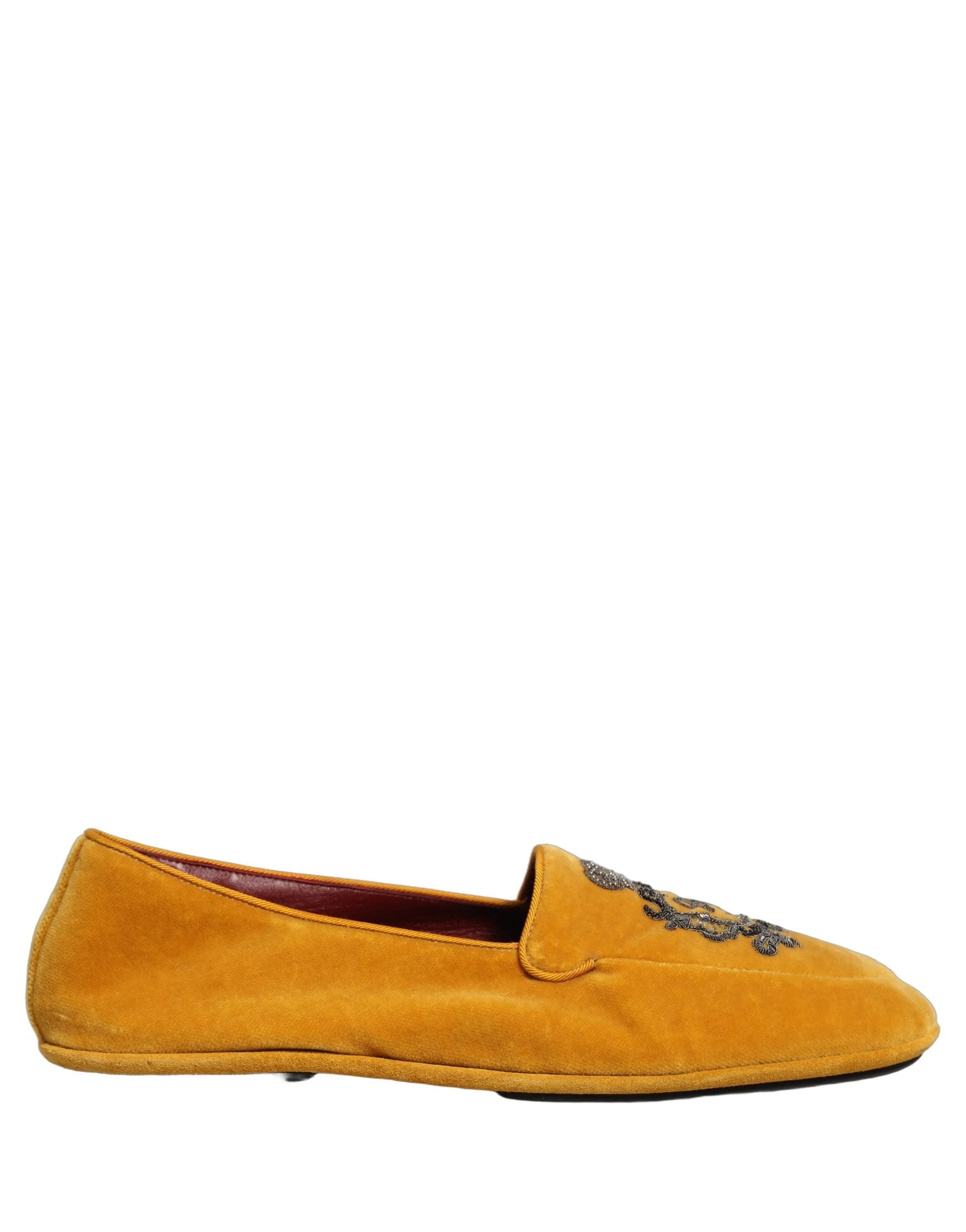 Pair of Dolce & Gabbana yellow velvet crown loafers presented in a three-quarter studio angle.