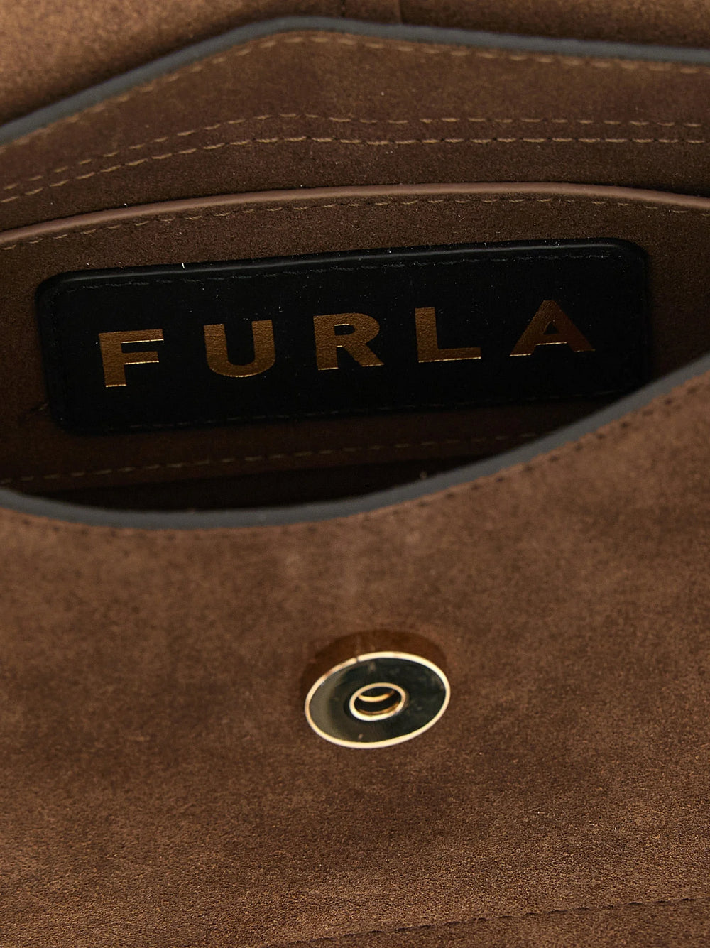 Detailní pohled na brown kabelku Furla s prvotřídní zrnitostí teletiny kůže a lešteným kovovým logem.