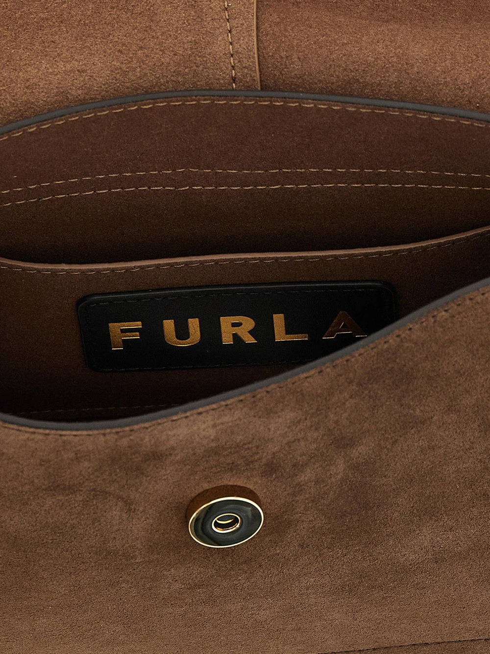 Detailní pohled na texturu kabelky Furla z telecí kůže, kovové logo a leštěnou zlatou hardware.