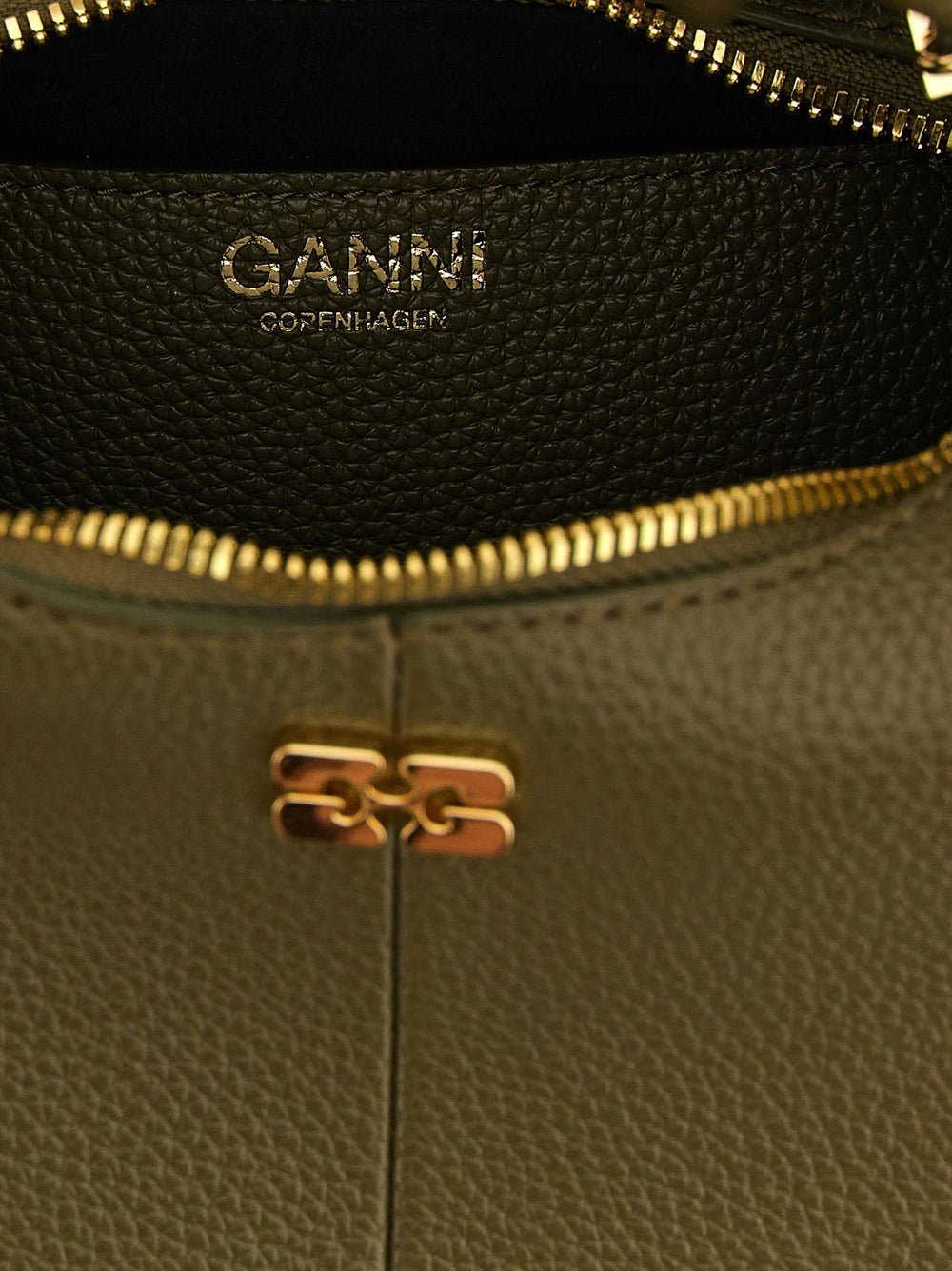 Detalhe de close-up da bolsa de mão Ganni, mostrando a textura têxtil refinada e a costura tonal precisa.