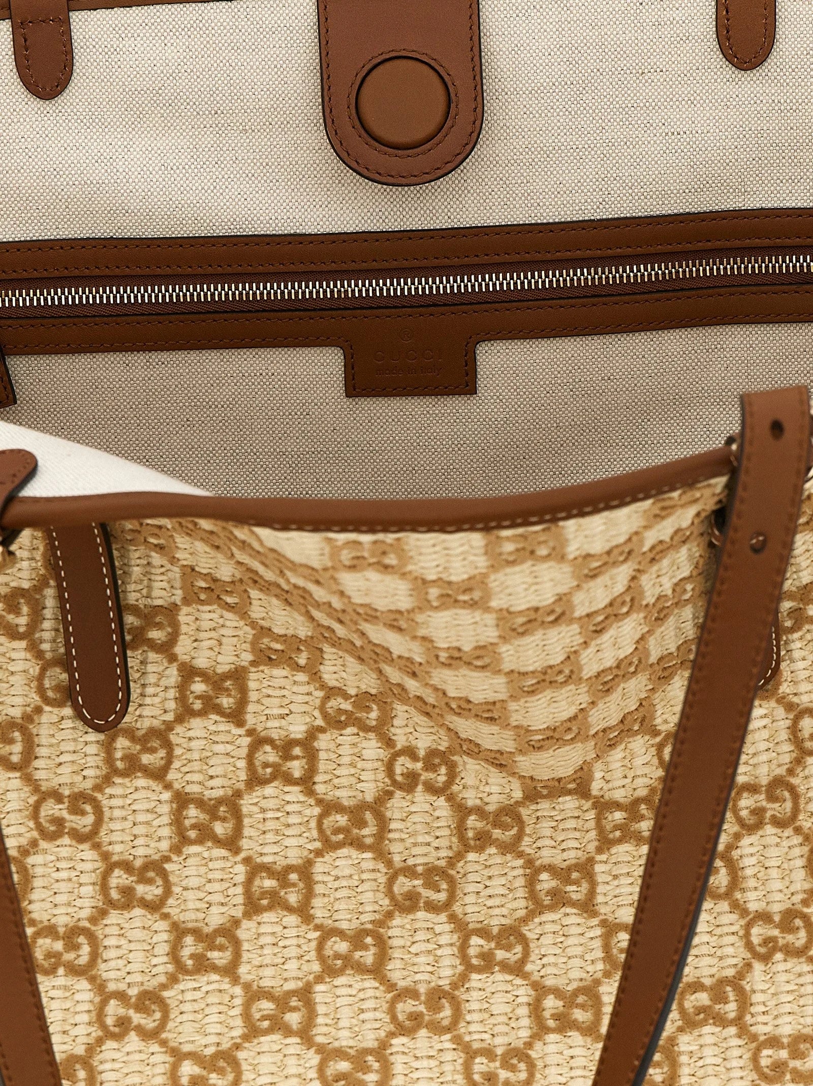 Close-up of the Gucci brown cotton fabric and hardware, showcasing the intricate weave and heritage logo detail.