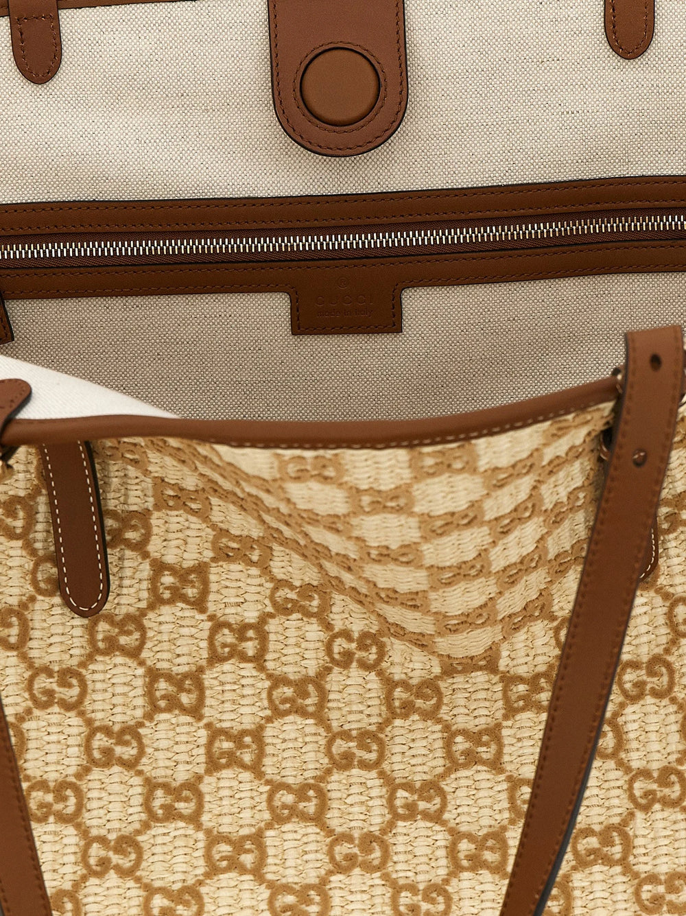 Close-up of the Gucci brown cotton fabric and hardware, showcasing the intricate weave and heritage logo detail.