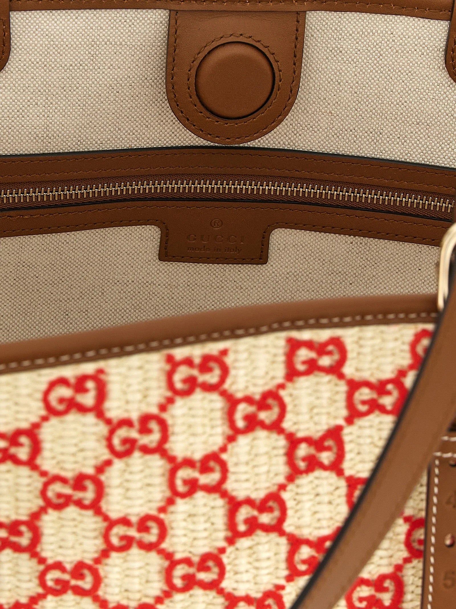 Detailní záběr na textil kabelky Gucci, odhalující složitý úplet a bohatou barevnou paletu bavlněné tkaniny.