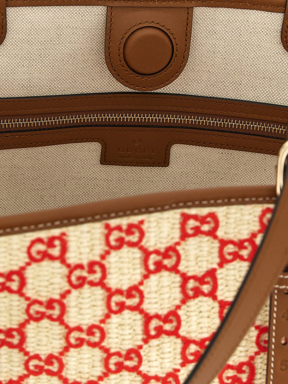 Detailní záběr na textil kabelky Gucci, odhalující složitý úplet a bohatou barevnou paletu bavlněné tkaniny.