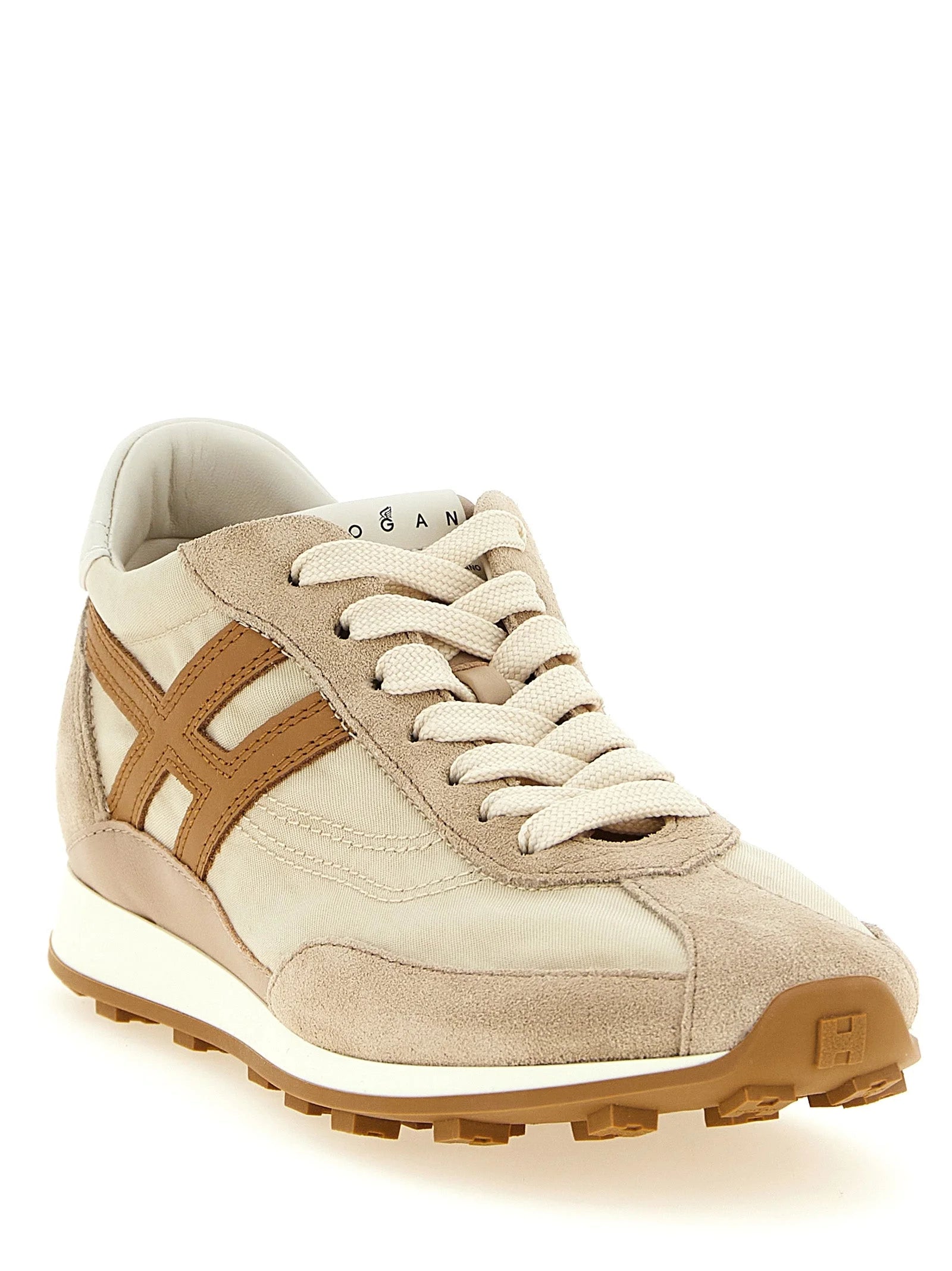 Perfil lateral de las zapatillas deportivas Hogan beige que muestran la tela de poliamida técnica y el diseño ergonómico de la entresuela deportiva.