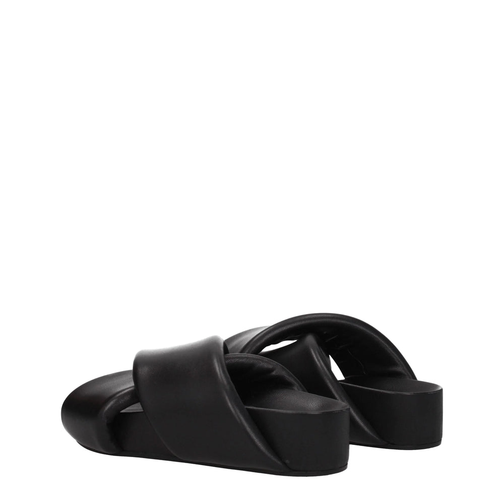 Détail de la semelle des sandales Jil Sander, révélant le logo en relief subtil et la texture fine du cuir grainé.