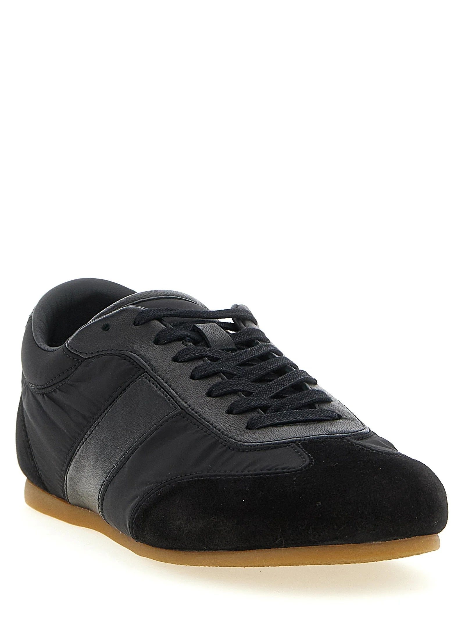 Profilo laterale di scarpe sportive Lemaire nere che mostra la snella costruzione in tessuto tecnico e la suola ergonomica.