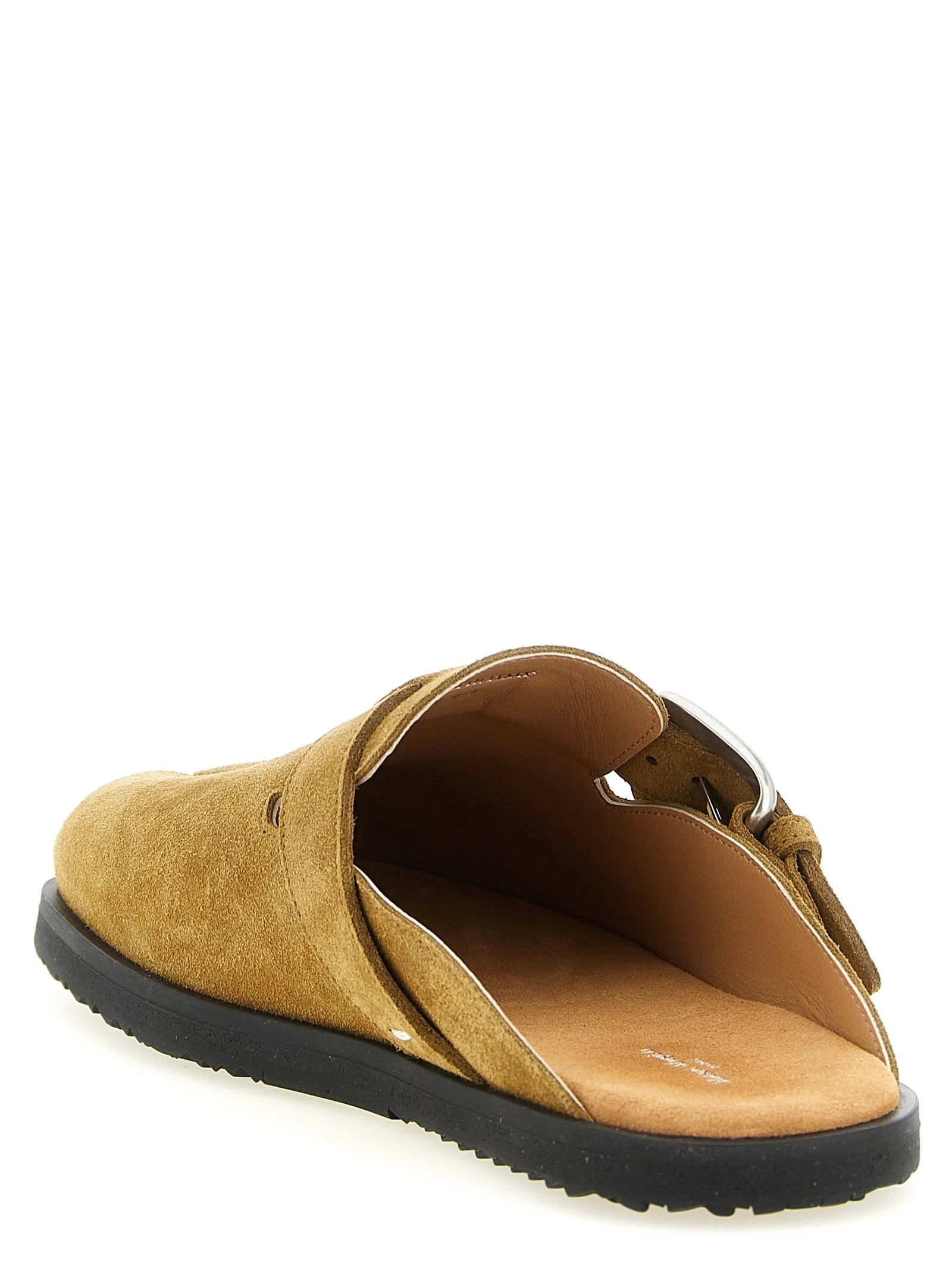 Baggrundsbillede af Maison Margiela brune slippers, der fremhæver det signerede hvide stiksøm på hælen.