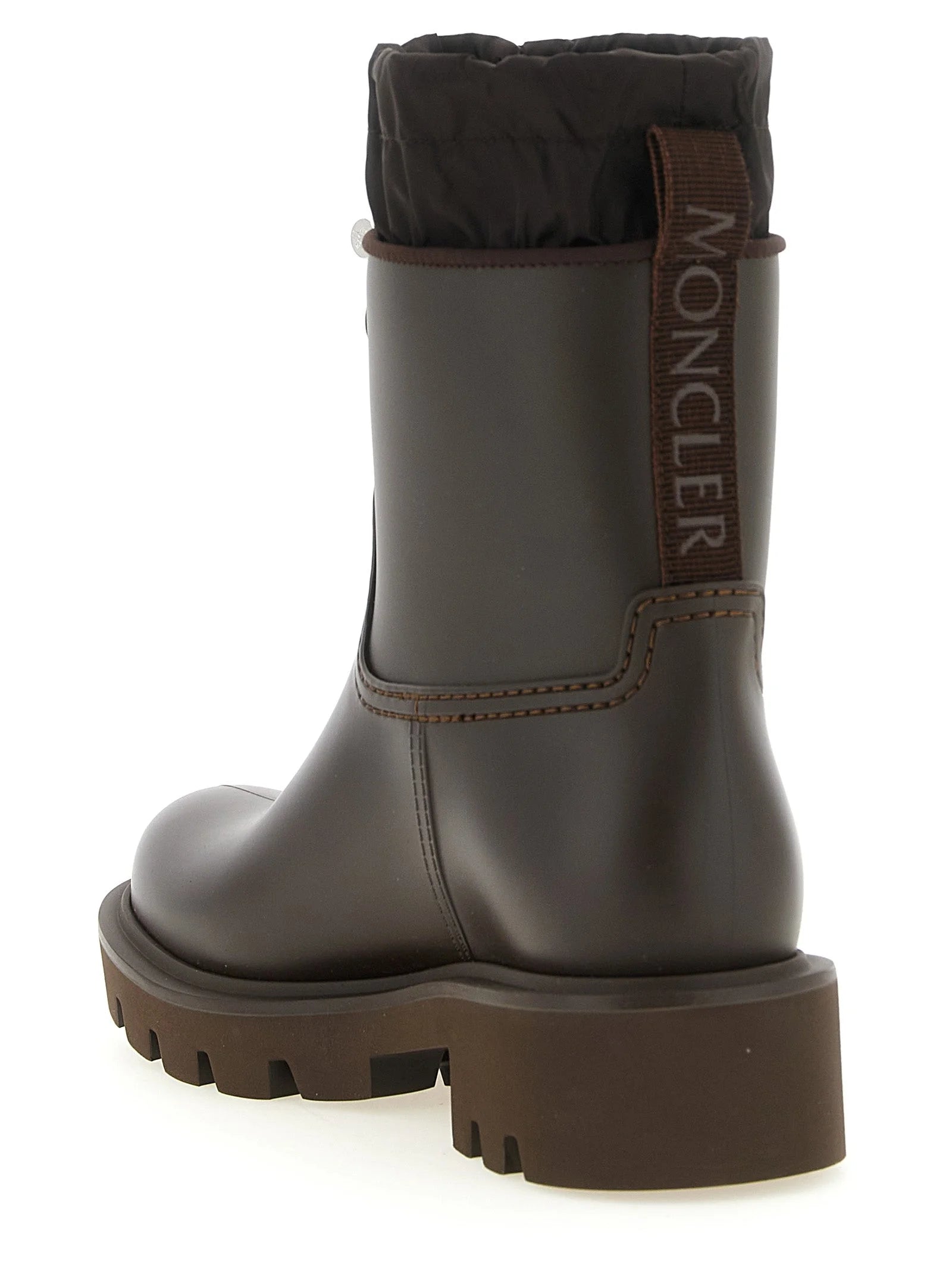 المنظر الخلفي لحذاء Moncler المصنوع من PVC يُبرز شريط السحب وشعار العلامة التجارية المميز على الكعب.