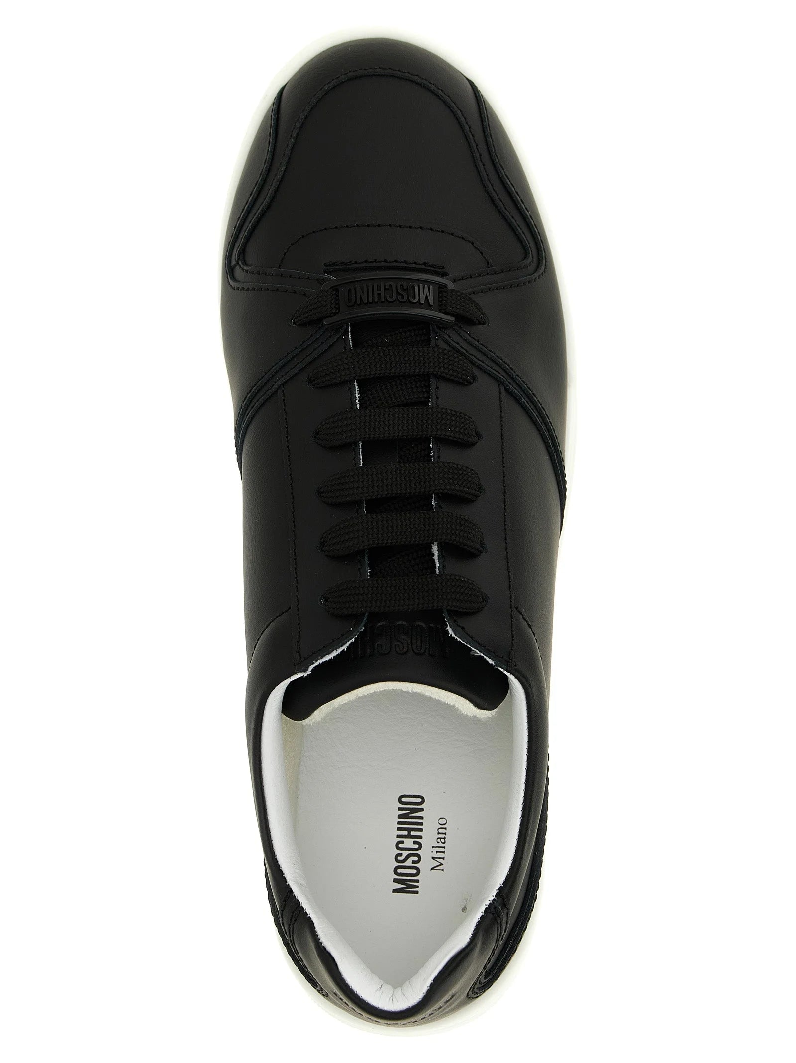 Närbild på Moschinos svarta lädersneakers textur och skosnören, vilket betonar varumärkets fokus på kvalitet.