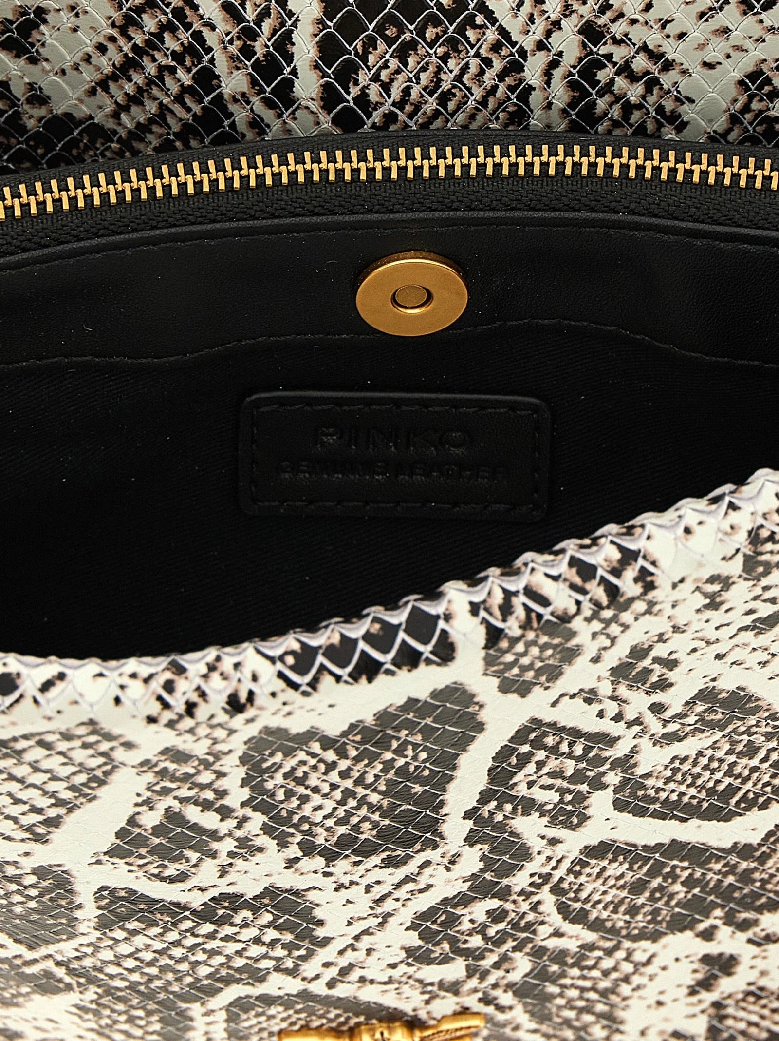 Close-up of the PINKO crossbody bag interior and iconic gold-tone bird ornament on the front flap.