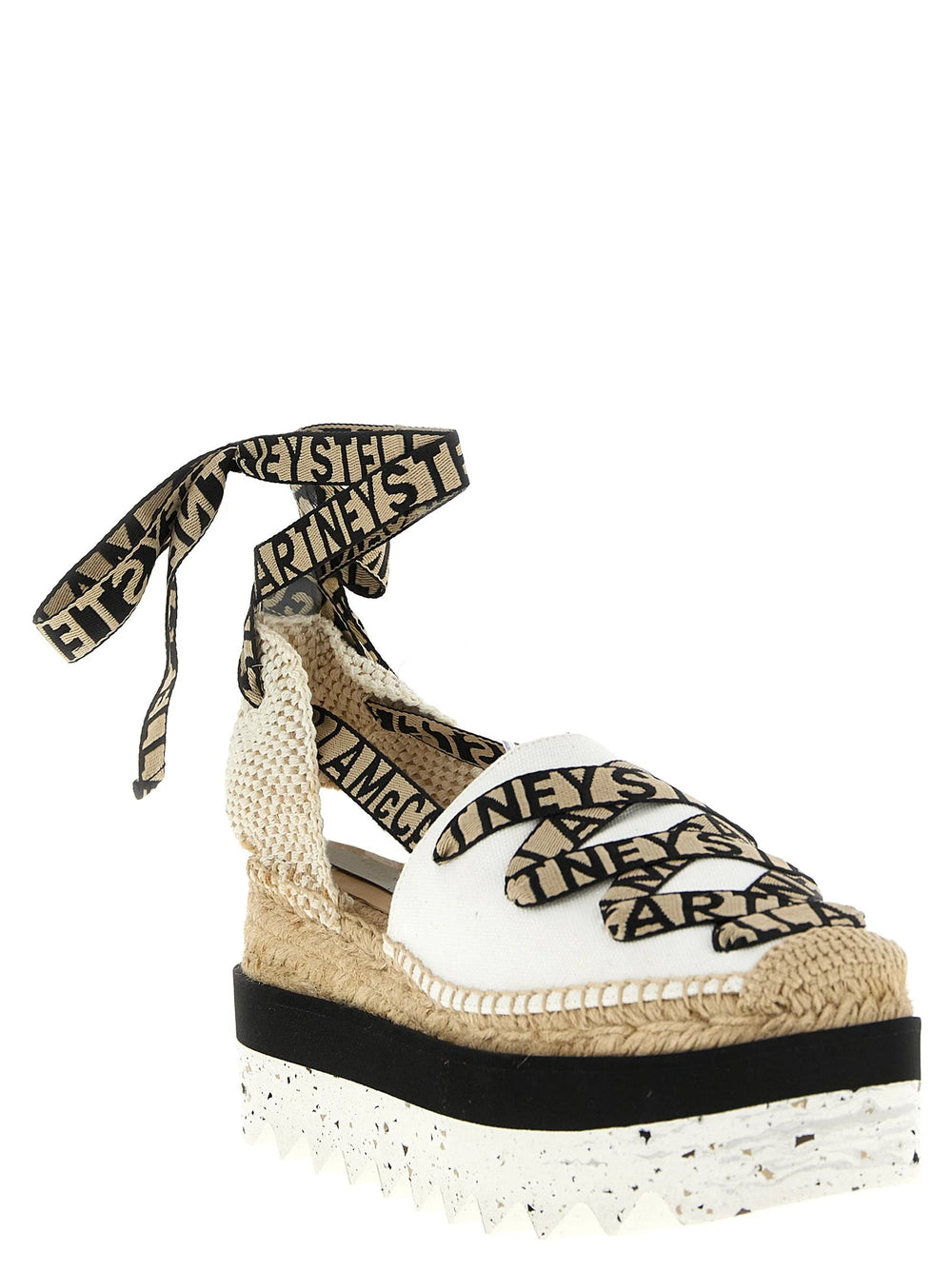 Side profile of Stella McCartney beige wedge sandals showcasing the architectural heel and secure ankle strap design.