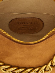 Dettaglio della texture in pelle marrone Twinset e del logo metallico lucido, che esalta l'artigianato ispirato all'Italia.