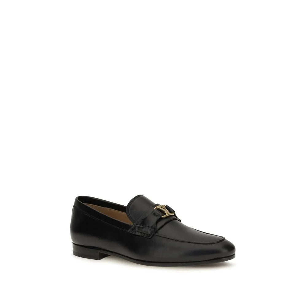 Profil latéral des mocassins Valentino Garavani en cuir noir, talon bas et artisanat italien raffiné.