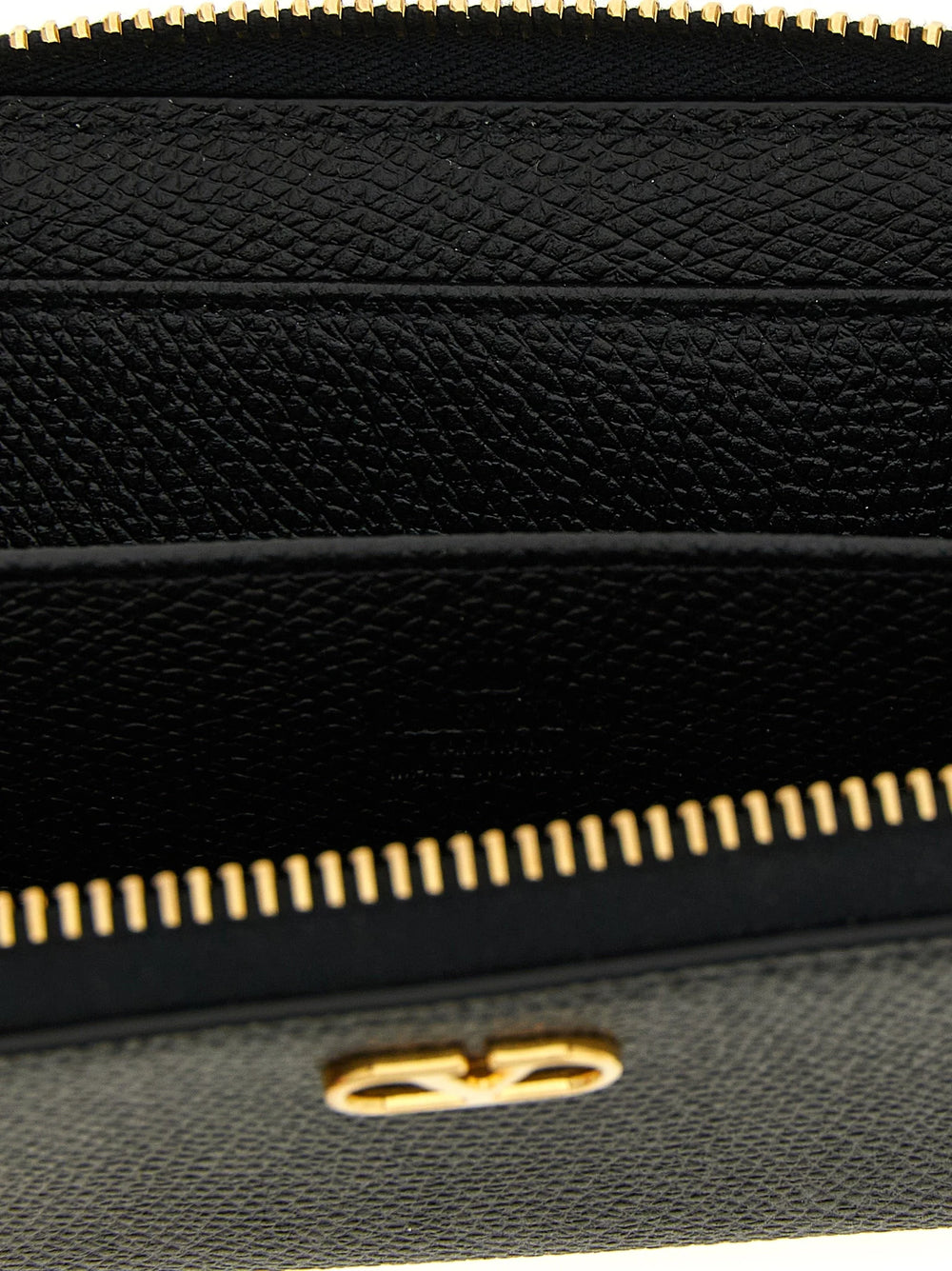 Close-up van het gladde zwarte rundleer en het gouden VLogo embleem op een Valentino Garavani luxe kaarthouder.