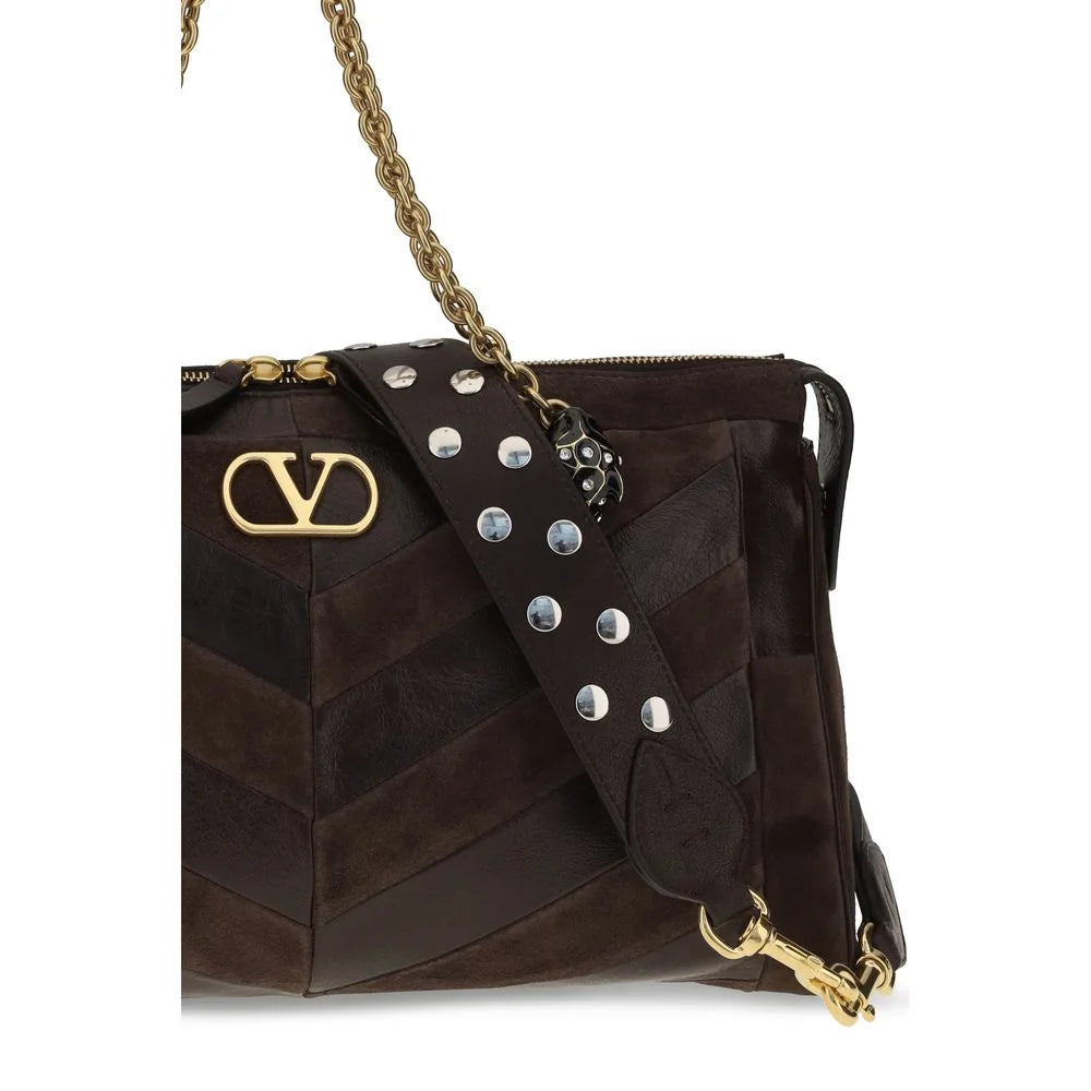 Primer plano del bolso Bos Taurus de Valentino Garavani que se centra en la textura del cuero de becerro premium y el hardware metálico.