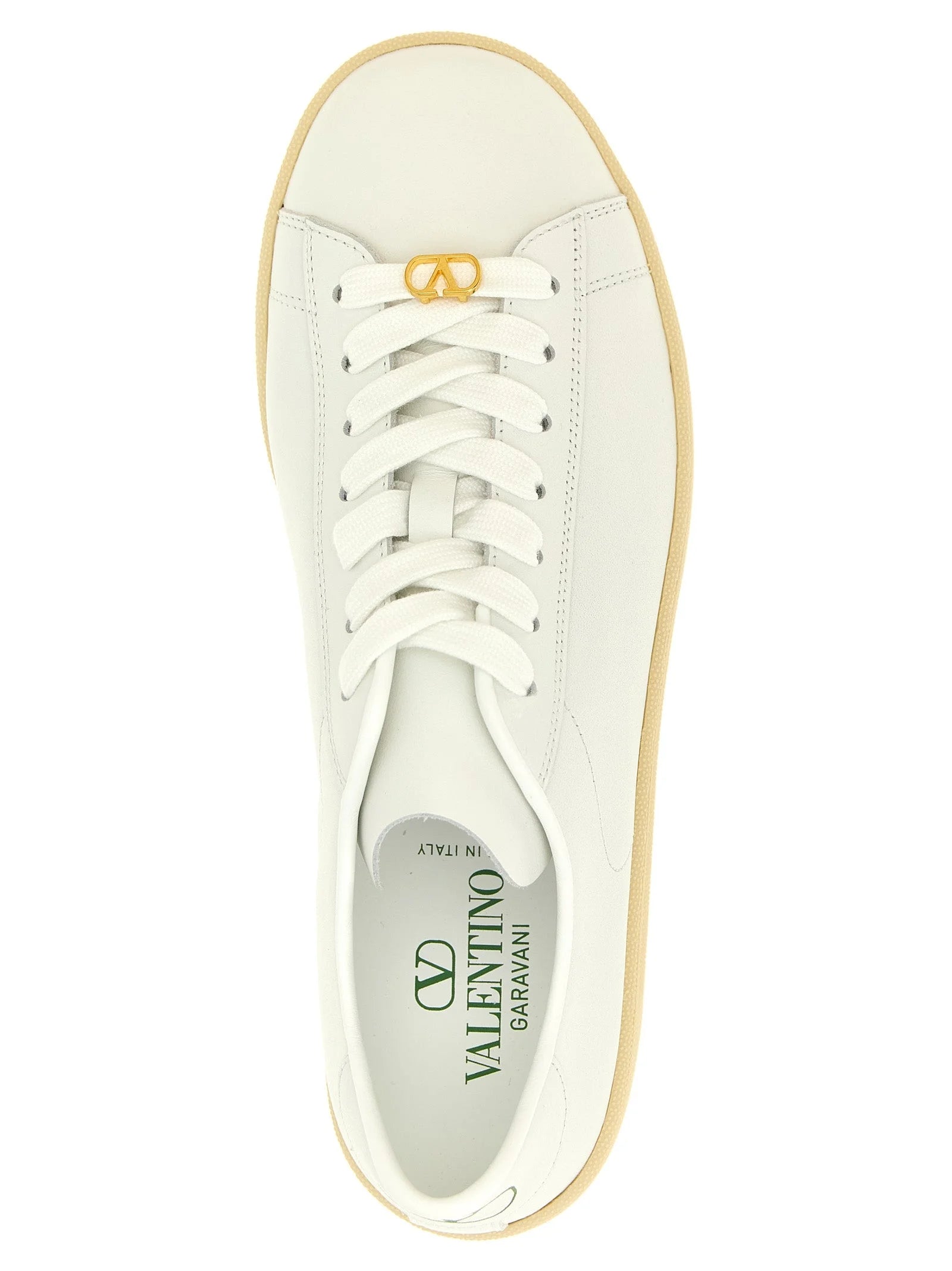 Close-up of the premium white calfskin leather texture and signature branding on the Valentino Garavani sneaker tongue.