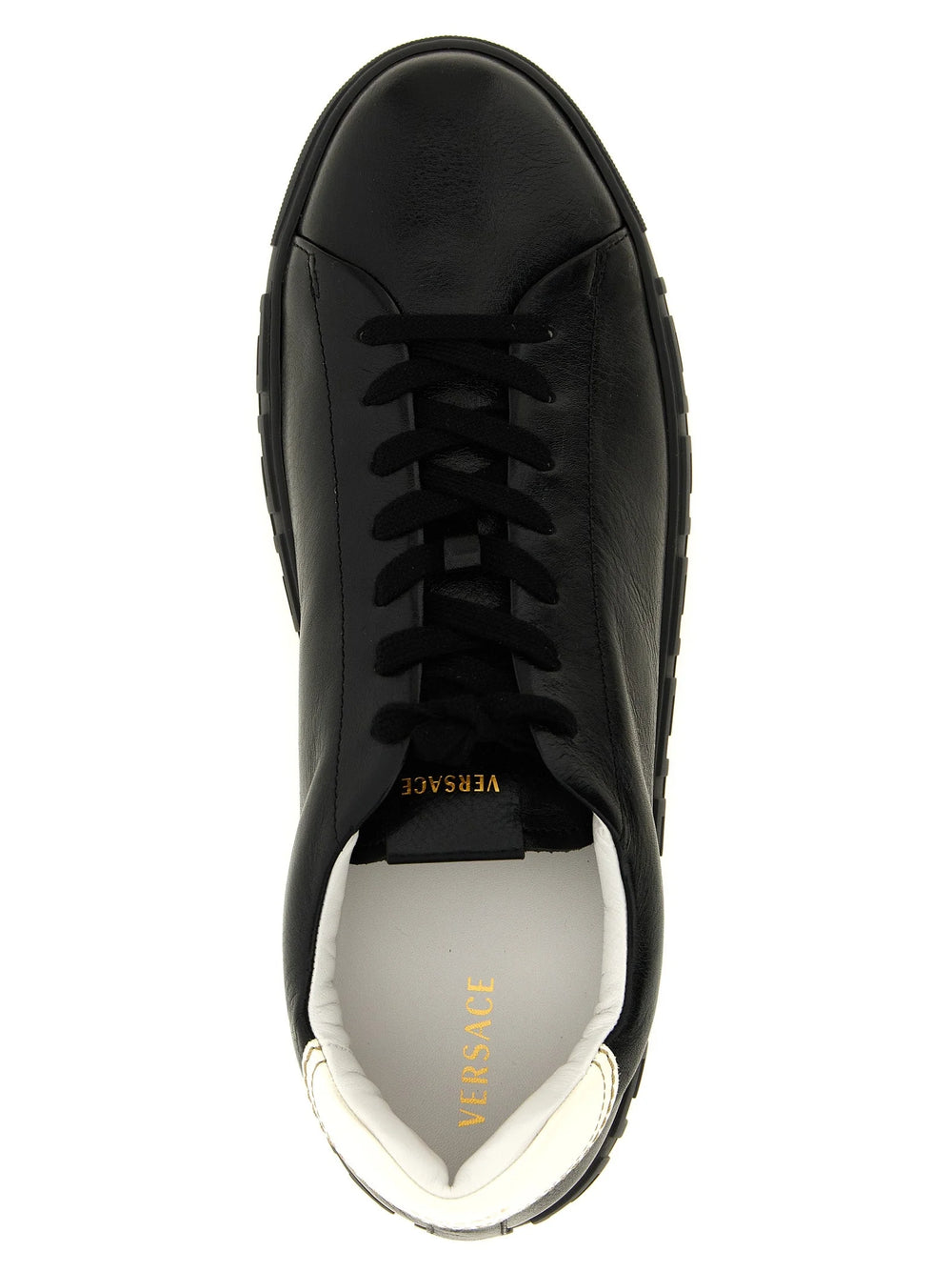 Zbliżenie na gładką fakturę skóry cielęcej i stonowane przeszycia w tych luksusowych, dwukolorowych sneakersach Versace.