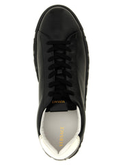 Zbliżenie na gładką fakturę skóry cielęcej i stonowane przeszycia w tych luksusowych, dwukolorowych sneakersach Versace.