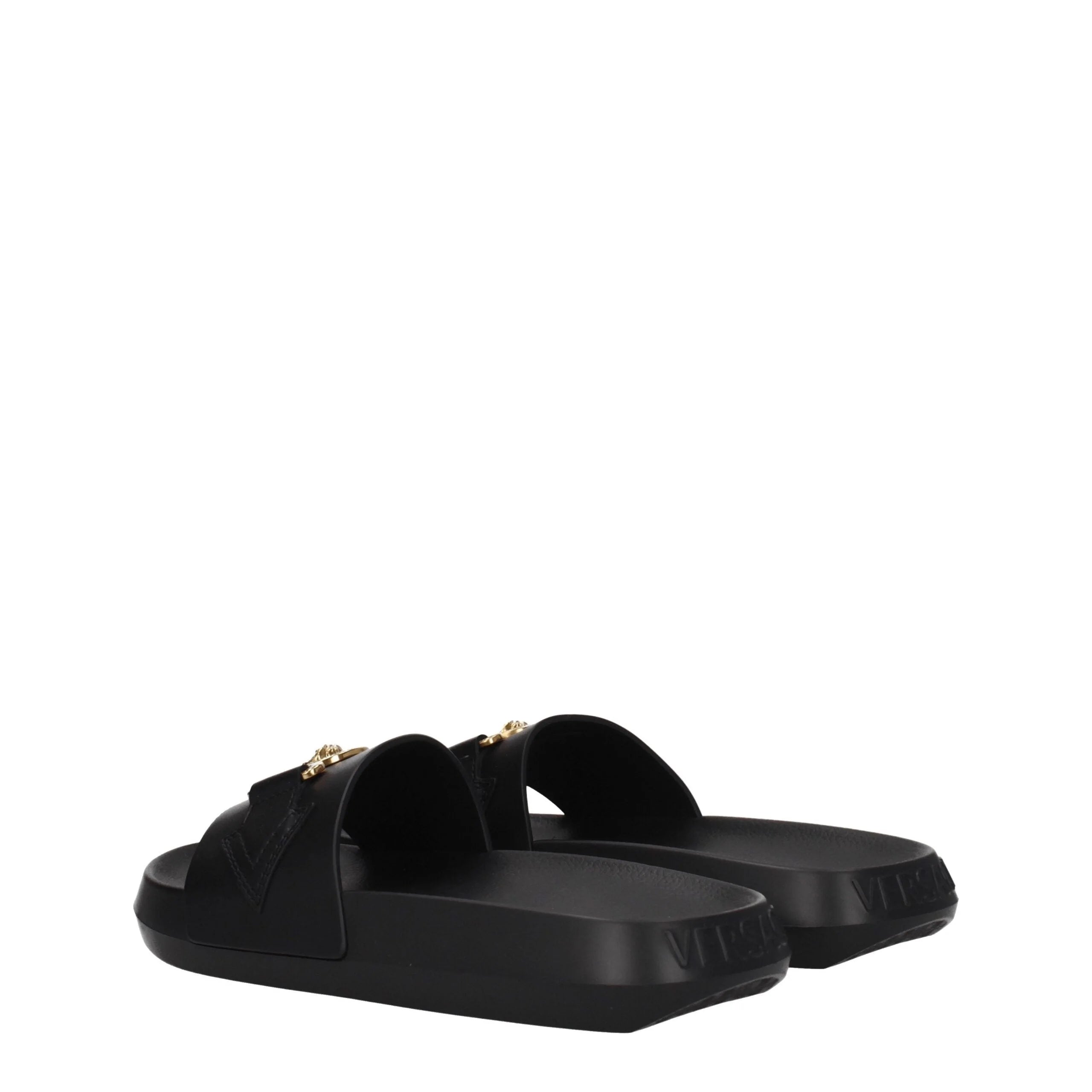 Detalle de cerca del grano de cuero negro flexible y la costura tonal precisa en las exclusivas sandalias de Versace.