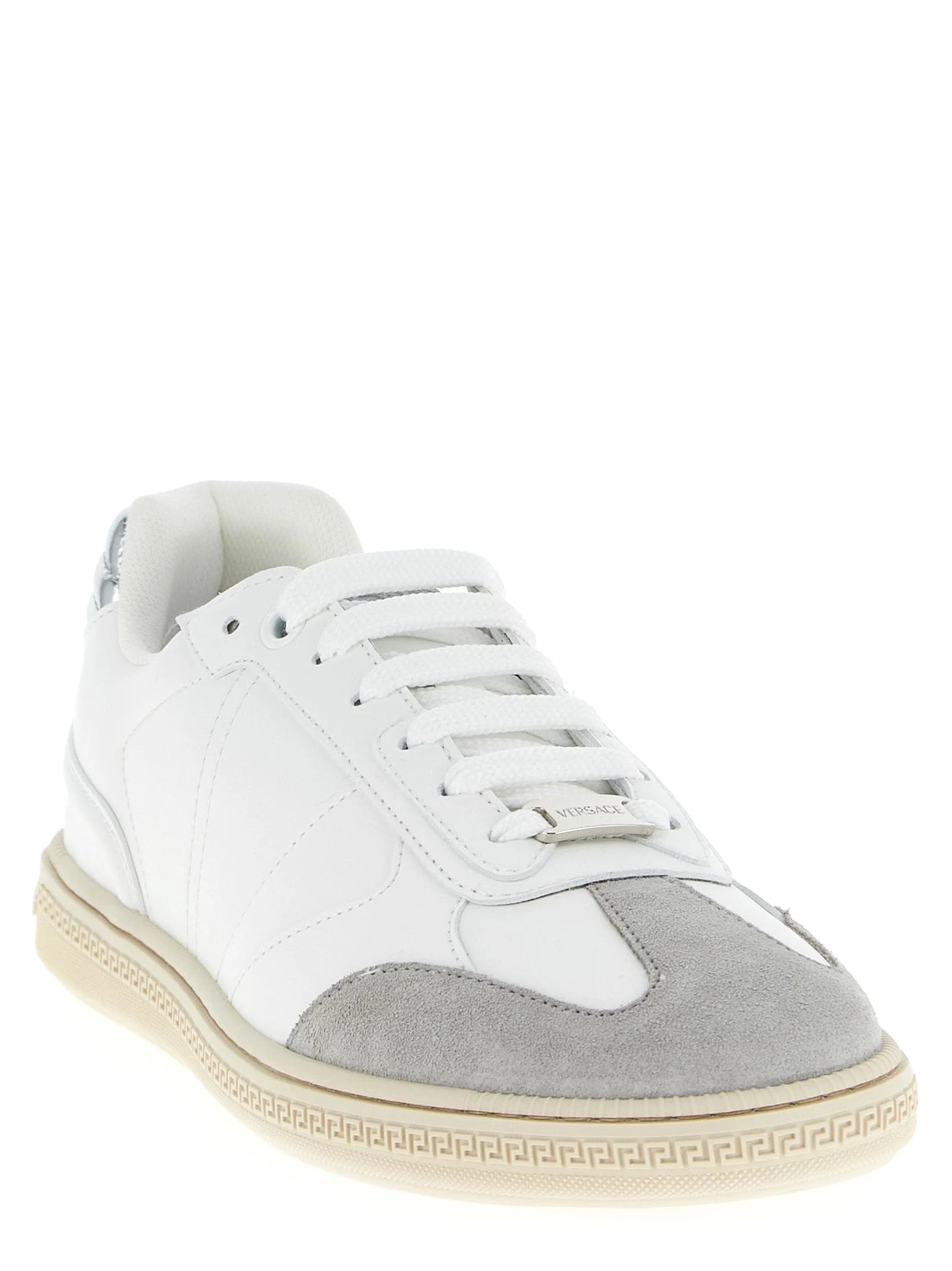 Sideprofil af Versace hvide lædersneakers, der viser de rene arkitektoniske linjer og holdbare gummisål.